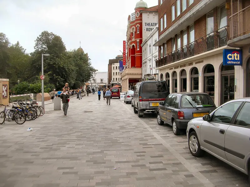 The paved shared-space street of New Road in Brighton, with bicycles, benches and Regency buildings