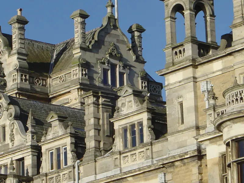 Ornate Victorian stone turrets and chimneys of Thoresby Hall against a blue sky
