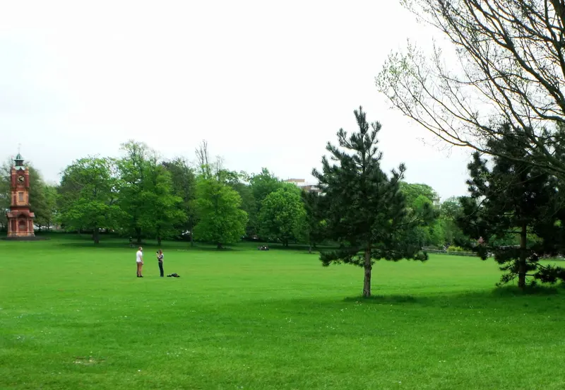 Wide green lawns and trees in Preston Park, Brighton