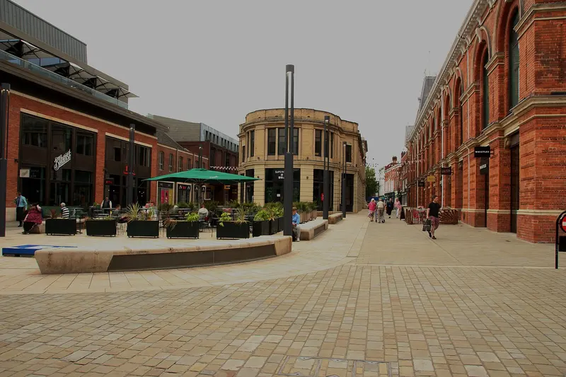 The paved Cornhill square in Lincoln with cafe seating, lamp posts and the brick Corn Exchange