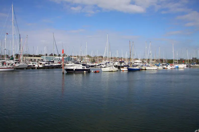 Rows of yachts moored in Lymington harbour on calm blue water
