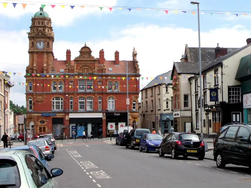 Newtown's High Street hung with bunting, leading to a red-brick Victorian clock tower building