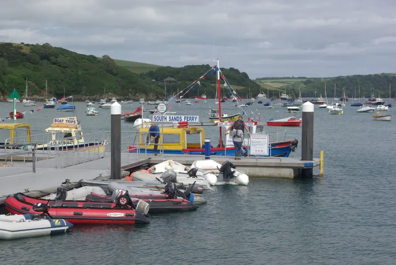Small boats and pontoons at Whitestrand Quay in Salcombe, with wooded hills across the estuary