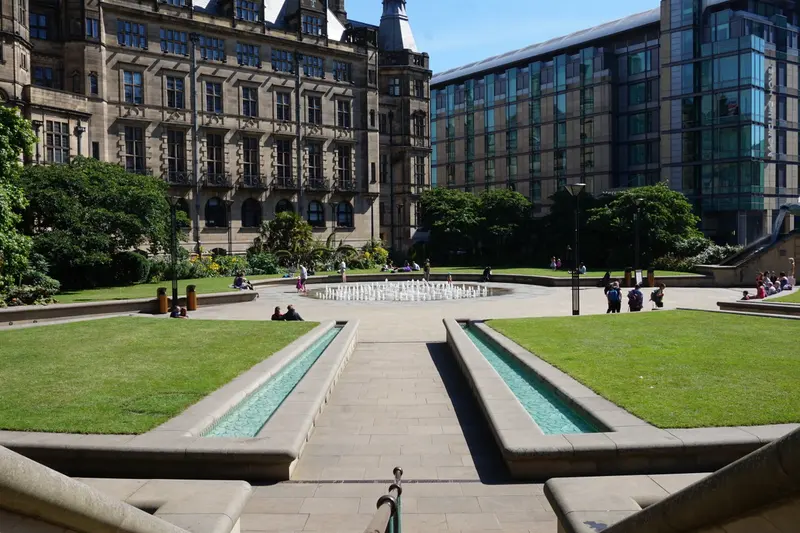 Lawns and stone water channels in the Peace Gardens, with Sheffield Town Hall and modern buildings behind