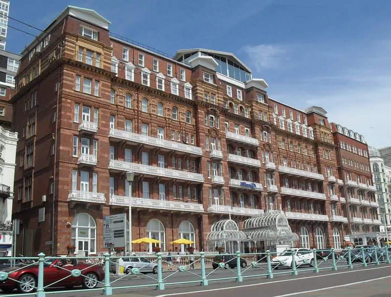 The large red-brick Victorian Metropole hotel on Brighton's seafront under a blue sky